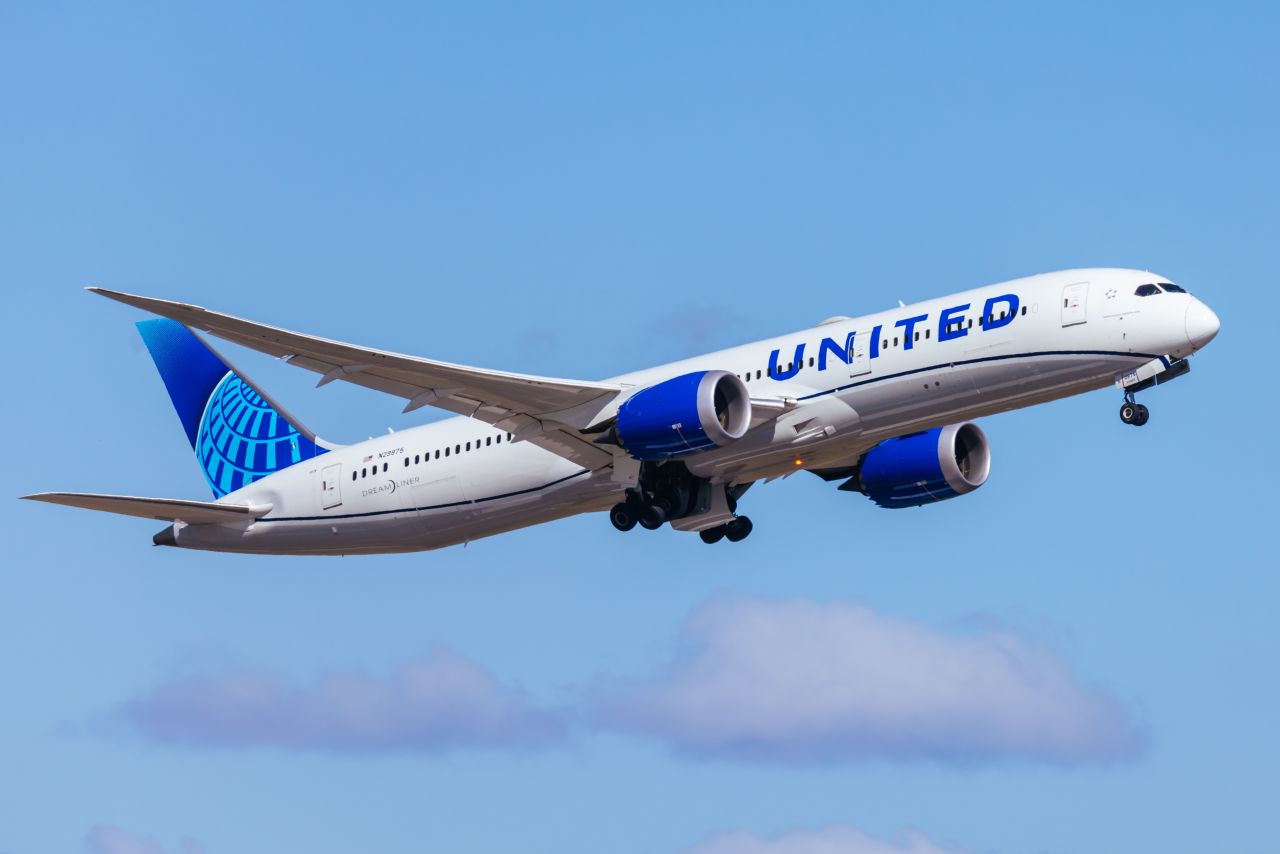 united airlines plane in flight, United Airlines Just Made It Official — No Headphones Could Mean a Permanent Ban
